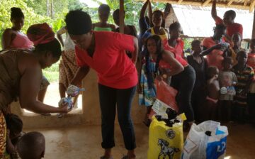 Mrs Kupee and team distributing food items to villagers along the  Buchana High way, Grand Bassa County.