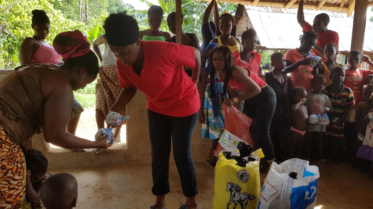 Mrs Kupee and team distributing food items to villagers along the  Buchana High way, Grand Bassa County.