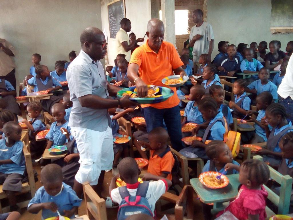 Senator Kupee and team distributing food at a school feeding program in Voinjama City, Lofa county.